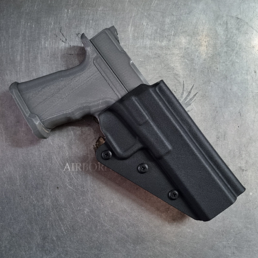Black gun holster with magazine on a metallic surface