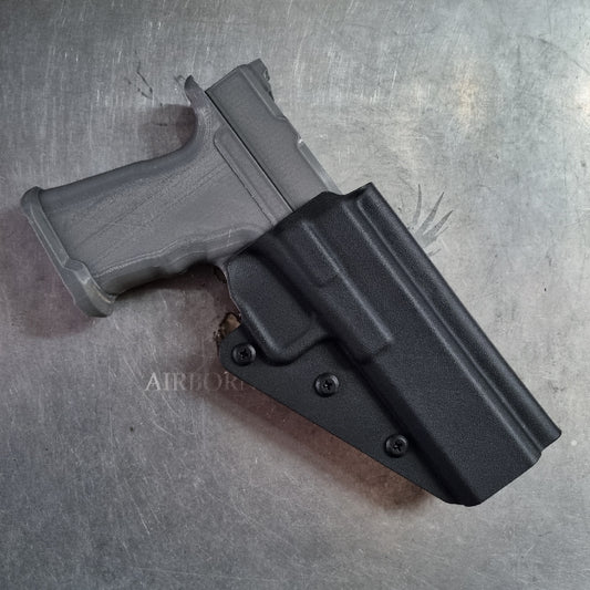 Black gun holster with magazine on a metallic surface